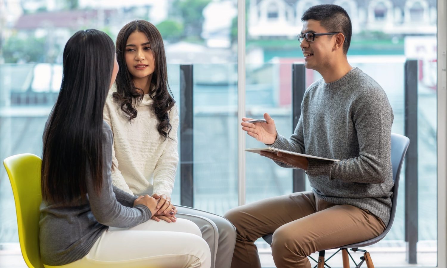 Asian male professional psychologist doctor giving the consult to Lesbian lovers patients
